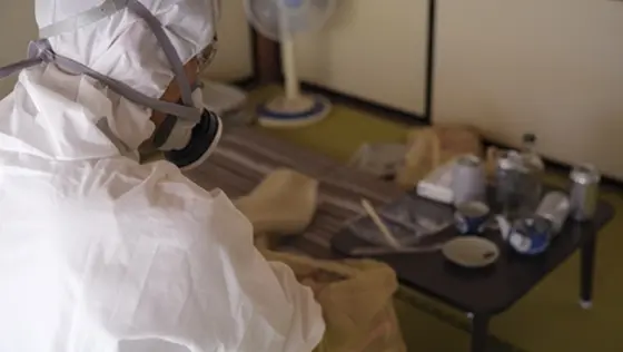 防護服を着用して室内の特殊清掃を行う様子